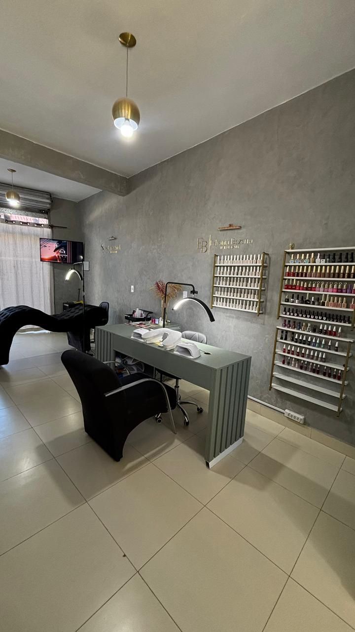Espaço do nail bar do studio com bancada e expositor de esmaltes